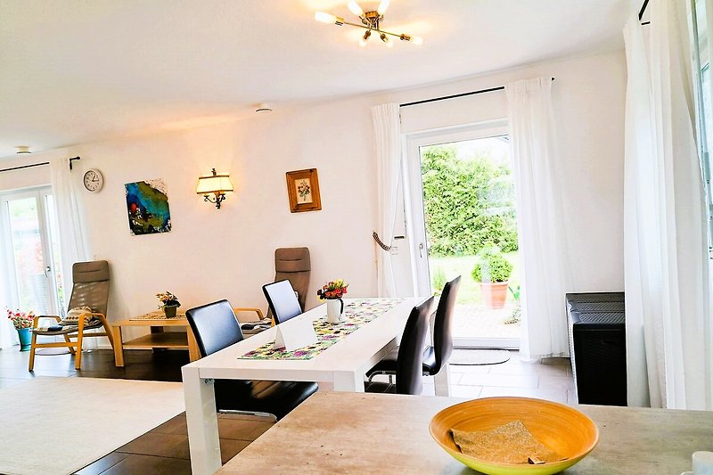 Wohnzimmer mit Tisch, Pflanze, Beleuchtung und Kunst.