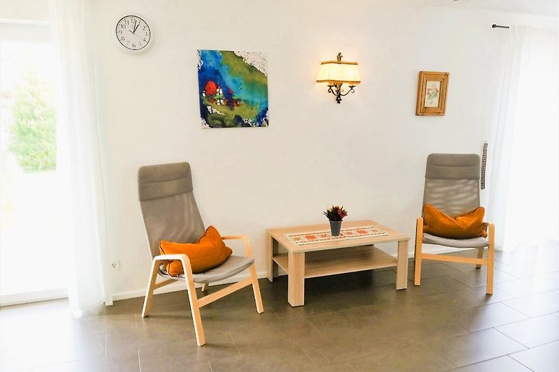 Wohnzimmer mit gemütlichem Mobiliar und Kunst.