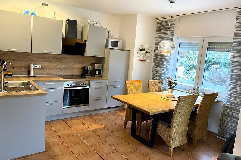 Moderne Küche mit Holzmöbeln, Spüle und Fenster.