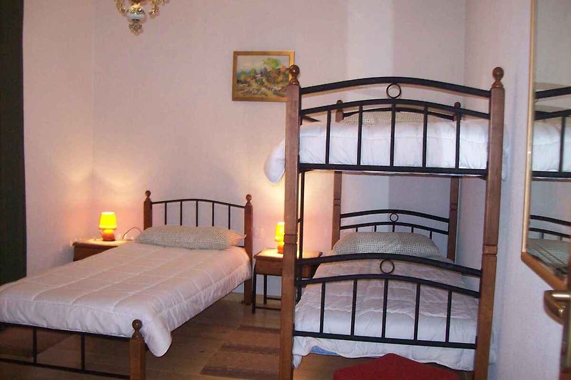 Slaapkamer met éénpersoonsbed en stapelbed