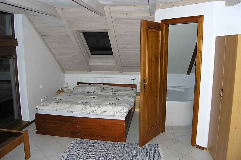 Schlafzimmer mit Stufen ins Kinderschlafzimmer im Dachgeschoss