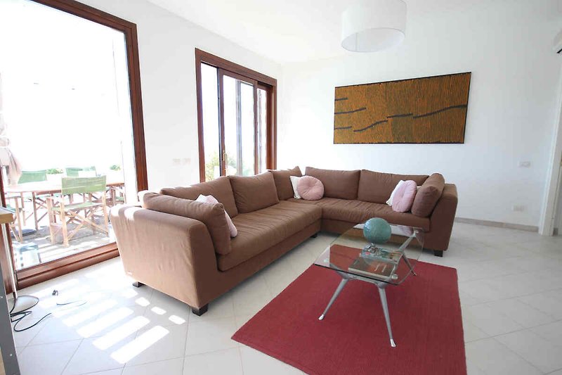 Gemütliches Wohnzimmer mit brauner Couch und stilvoller Inneneinrichtung.