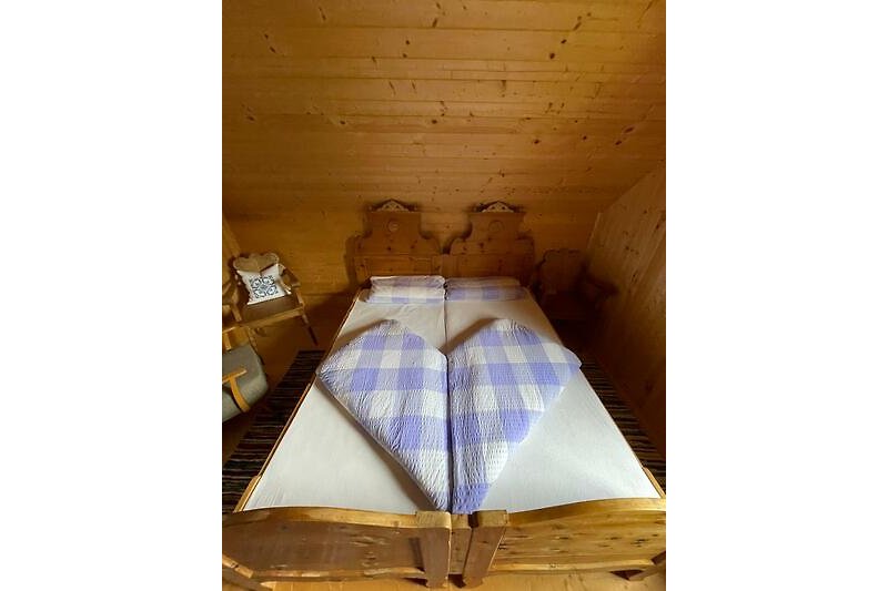 Gemütliches Schlafzimmer mit Holzbettgestell und gemütlichen Kissen.