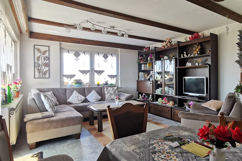 Gemütliches Wohnzimmer mit bequemer Couch, stilvoller Beleuchtung und Pflanzendeko.