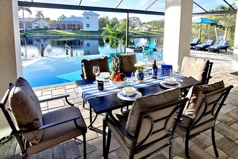 Rent this beautiful property with outdoor furniture, a stunning view of the water, and a stylish dining area.