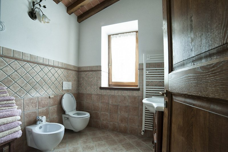 Badezimmer mit modernen Armaturen und Fliesen.