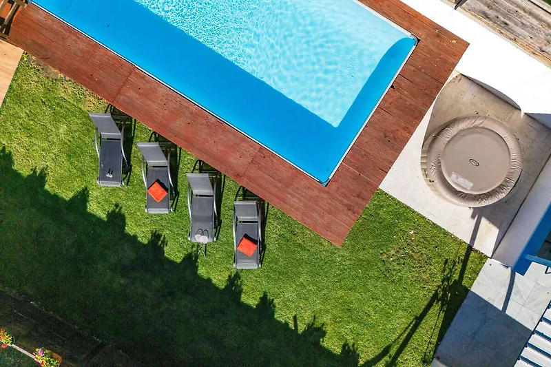 Poollandschaft mit Liegen, Sonnenschirmen und Outdoor-Sitzmöbeln.