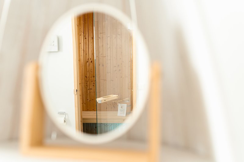 Stilvolles Zimmer mit Spiegel, Holzregal und Surfboard.