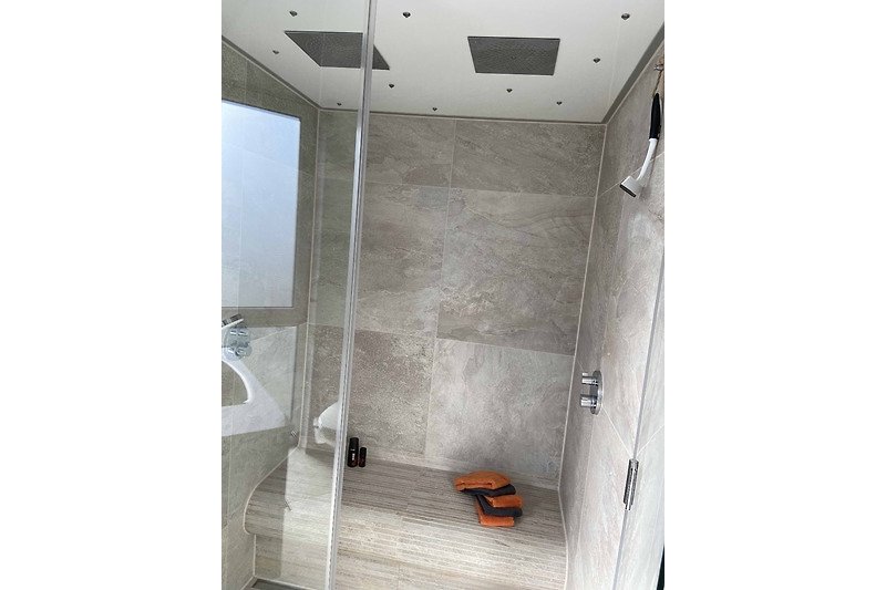Ein modernes Badezimmer mit Regendusche und Dampfkabine für besondere Relaxmomente.