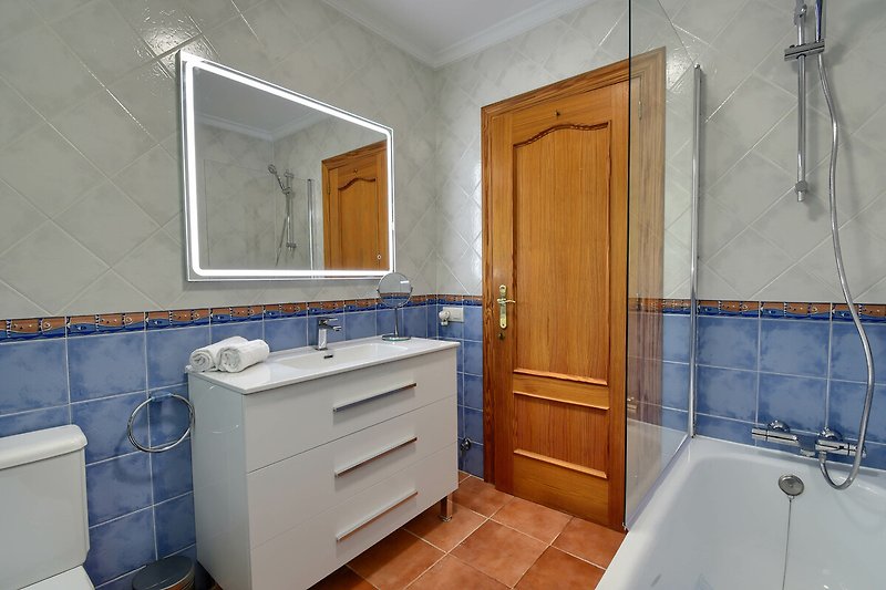Gemütliches Badezimmer mit lila Waschbecken und Holzboden.