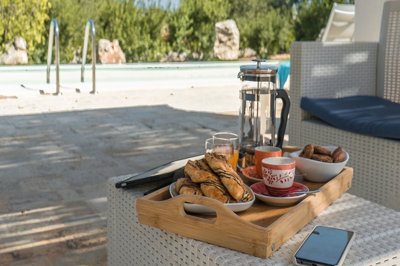 A delightful outdoor breakfast with fresh food and drinks on a sunny patio.