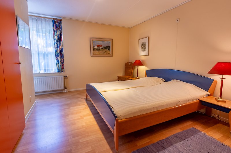 Een comfortabele slaapkamer met houten meubels en blauwe tinten.