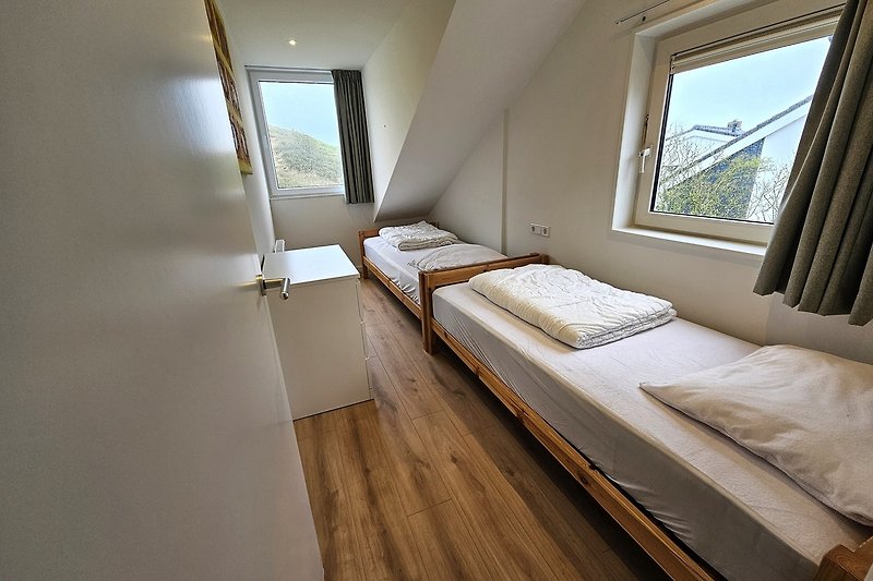 Schlafzimmer mit gemütlichem Bett und Fensterblick.