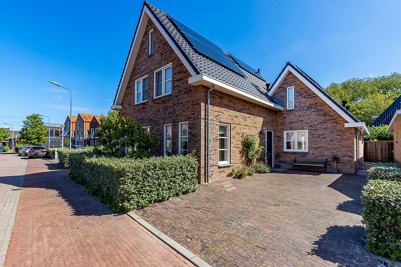 Charmantes Haus mit Garten, Ziegelmauerwerk, Sprossenfenstern und Einfahrt.