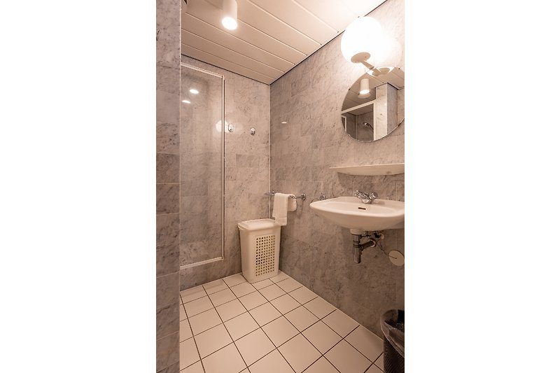 Mooie badkamer met een spiegel, wastafel en moderne armatuur.