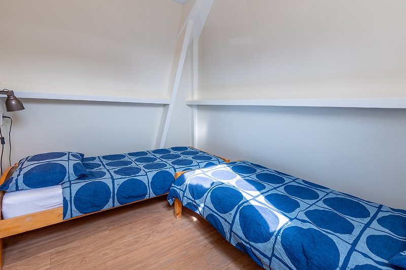 Comfortabele slaapkamer met houten bed en blauwe tint.