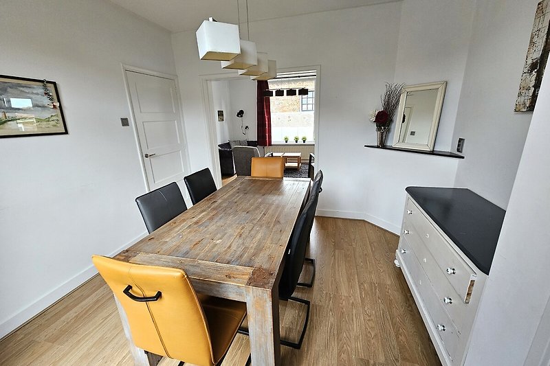 Holzmöbel in geräumigem Wohnzimmer mit Tisch und Stühlen.