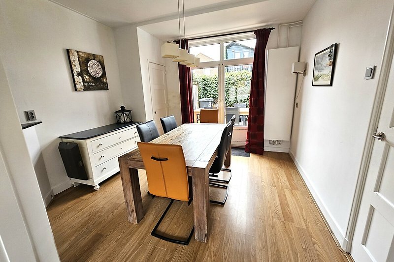 Wohnzimmer mit Holzmöbeln und Pflanzen.
