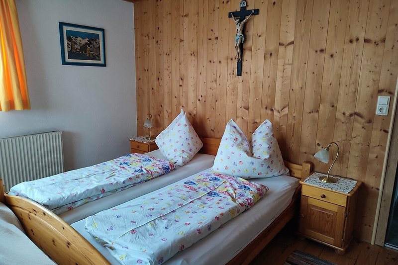 Gemütliches Schlafzimmer mit Holzmöbeln und blauen Textilien