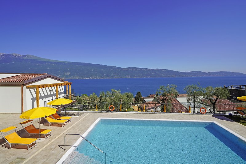 Moderne Villa mit Pool, Sonnenliegen und Blick aufs Meer.