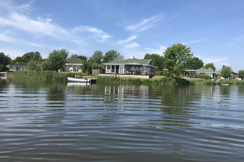 Direkter Zugang zum See mit Bootssteg, Wasserfahrzeugen und Schilfzonen.