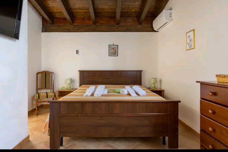 Gemütliches Schlafzimmer mit Holzmöbeln und bequemem Bett.