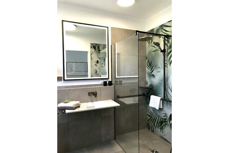 Ein stilvolles barrierefreies  Badezimmer im EG mit einem unterfahrbaren Waschtisch,