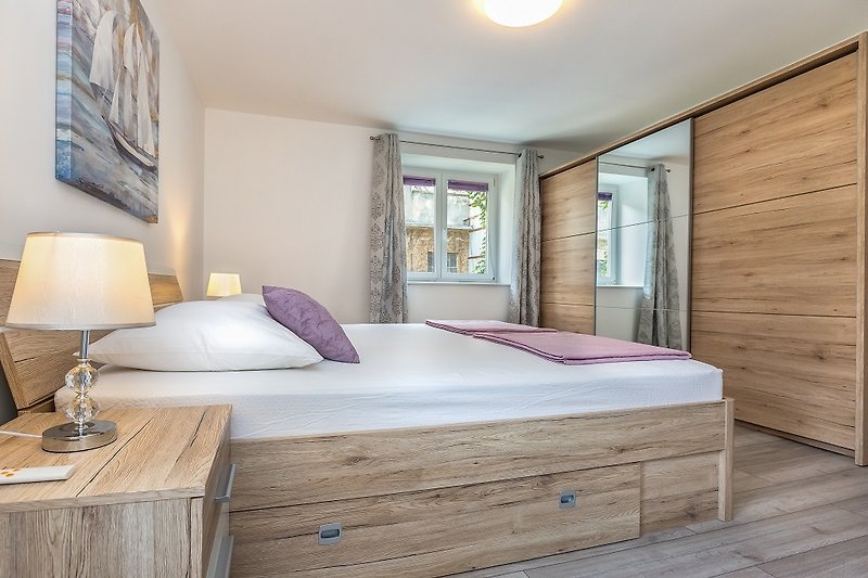 Prekrasna spavaća soba s udobnim krevetom i lijepim drvenim namještajem.