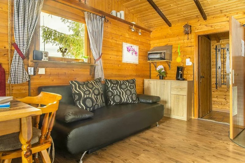Gemütliches Wohnzimmer mit Holzmöbeln, Couch und Kunstwerk.