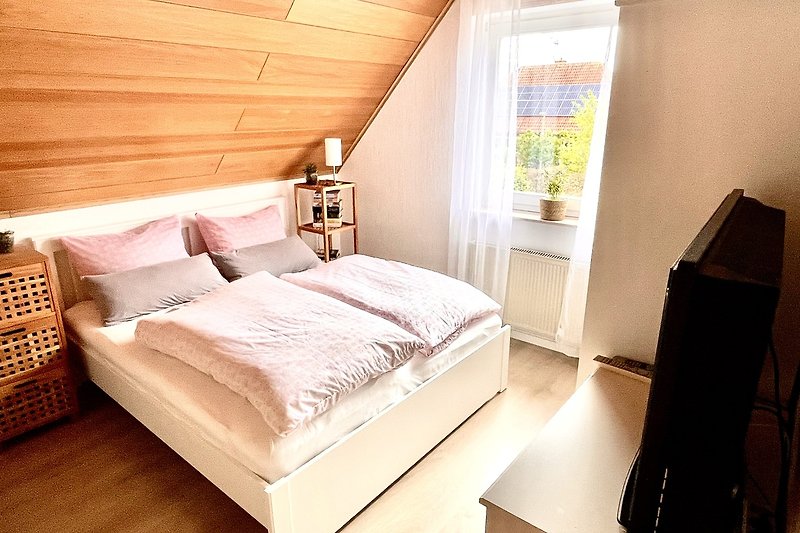 Modernes Schlafzimmer mit gemütlichem Bett und stilvoller Einrichtung.
