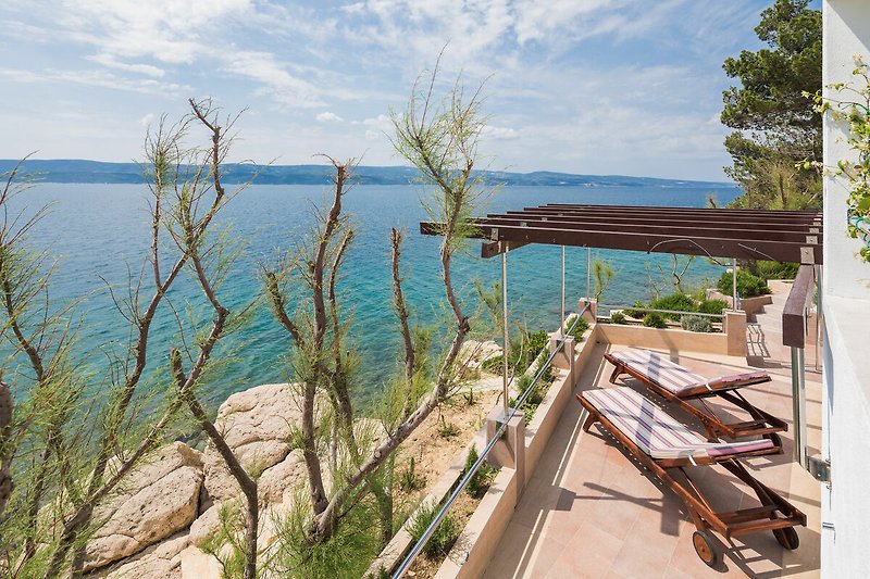 Schönes Ferienhaus am See mit Holzterrasse und Strandblick.