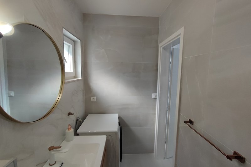 Modern bathroom with elegant fixtures, sleek sink, and stylish mirror.