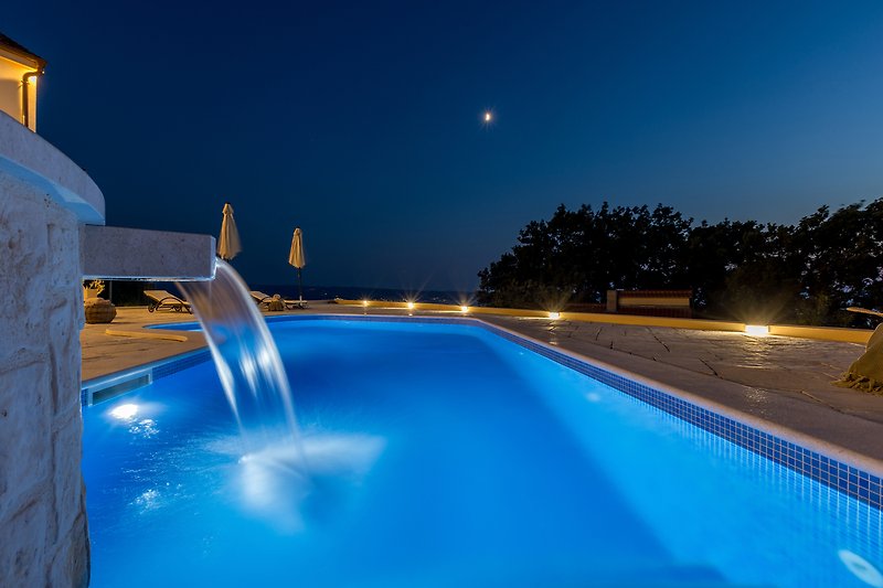 Luxury resort with pool, spa, and stunning night view.