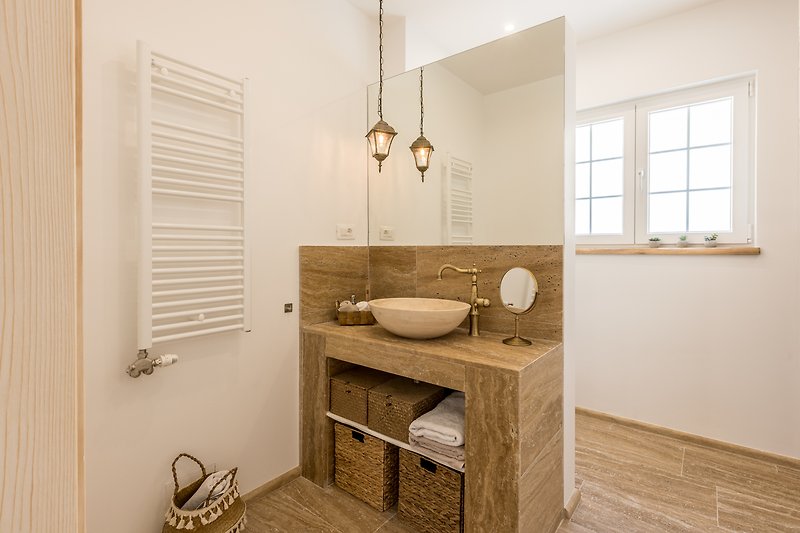 Modern bathroom with sleek cabinetry, stylish sink, and elegant fixtures.