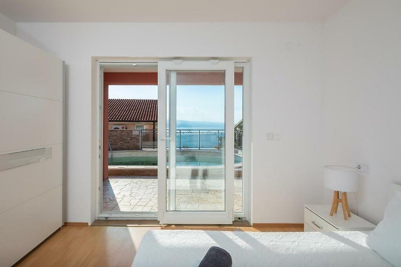 Modern apartment with elegant wood flooring, large windows, and balcony.
