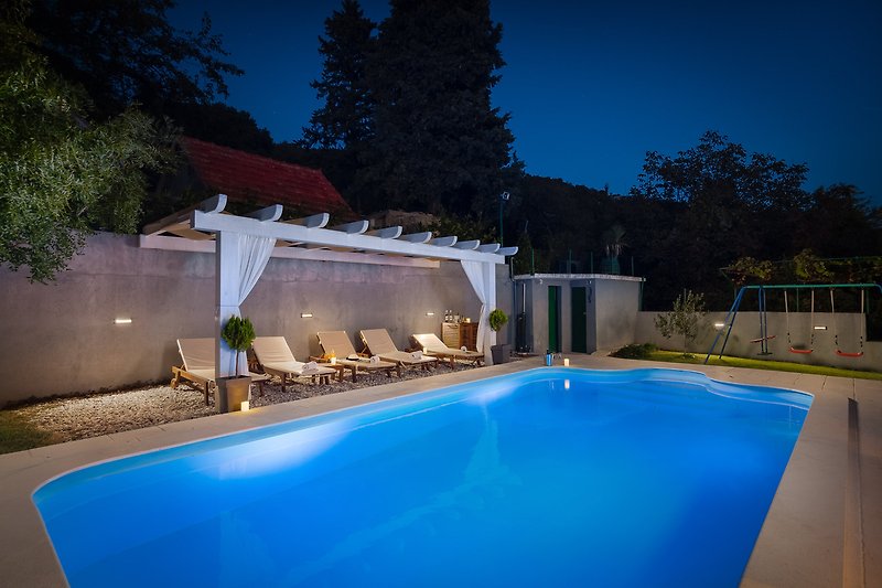 A serene outdoor oasis with a sparkling swimming pool and comfortable outdoor furniture.