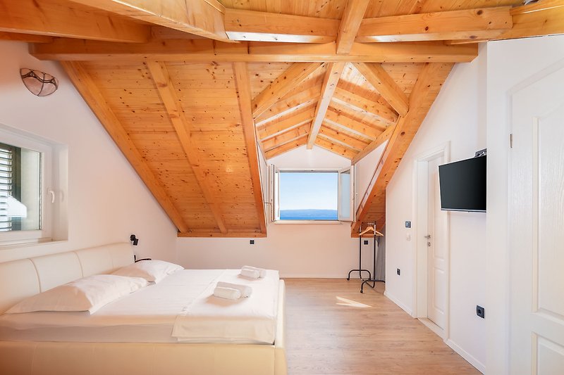 Gemütliches Schlafzimmer mit Holzboden und stilvollem Interieur.