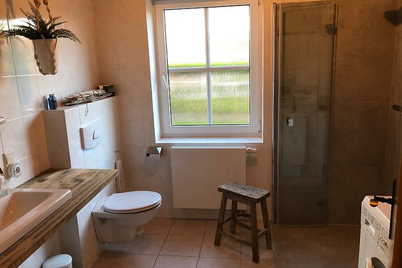 Schönes Badezimmer mit ebenerdiger Dusche, Fenster und Spiegel.