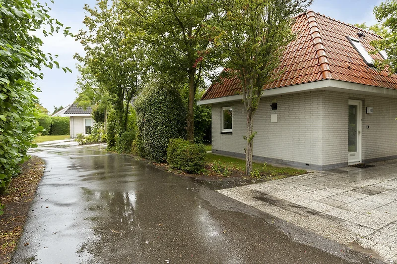 Großzügiges Haus mit gepflegtem Garten, Parkplatz und Zufahrt im Grünen.