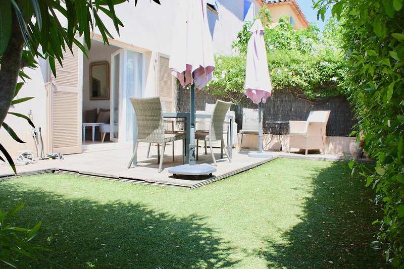 windgeschützter, grüner und sonniger Garten mit Stühlen und verschiedenen Liegestühlen zur Auswahl