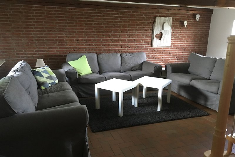 Gemütliches Wohnzimmer mit modernem Mobiliar und Holzboden.