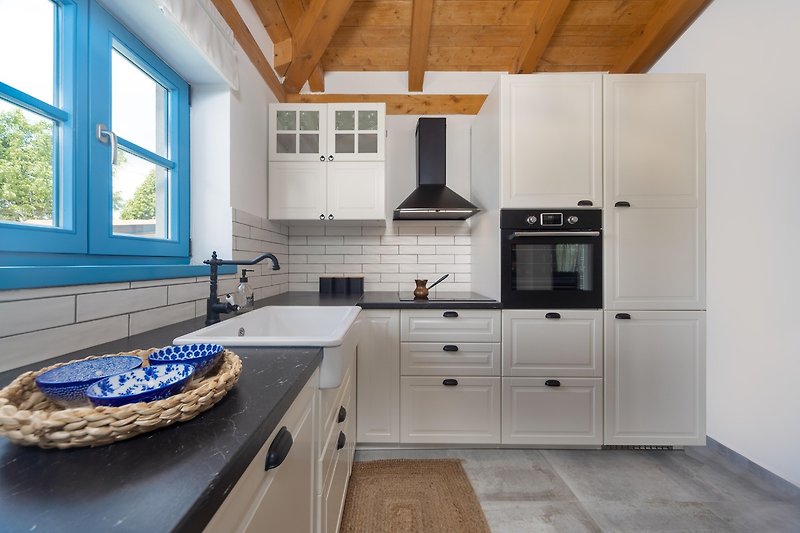 Predivan kuhinjski dizajn s drvenim elementima i plavim umivaonikom.