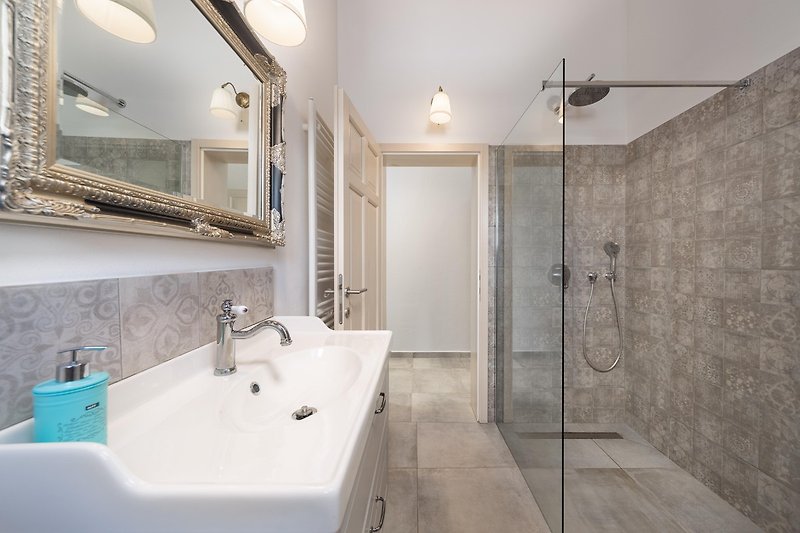 Moderan interijer kupaonice s drvenim elementima i lijepim osvjetljenjem.