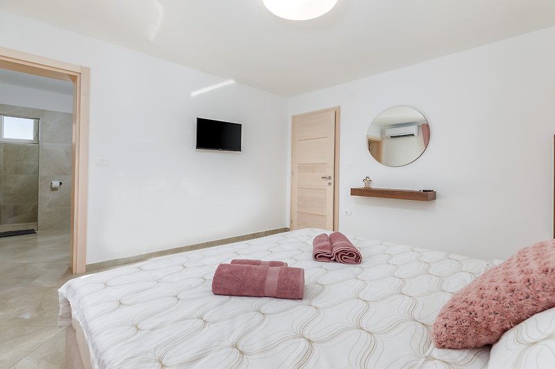 Elegantes Schlafzimmer mit Holzbett und stilvoller Einrichtung.