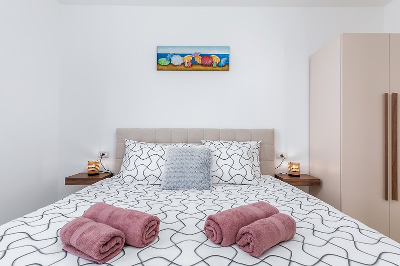 Stilvolles Schlafzimmer mit elegantem Bett und dekorativem Wandmuster.