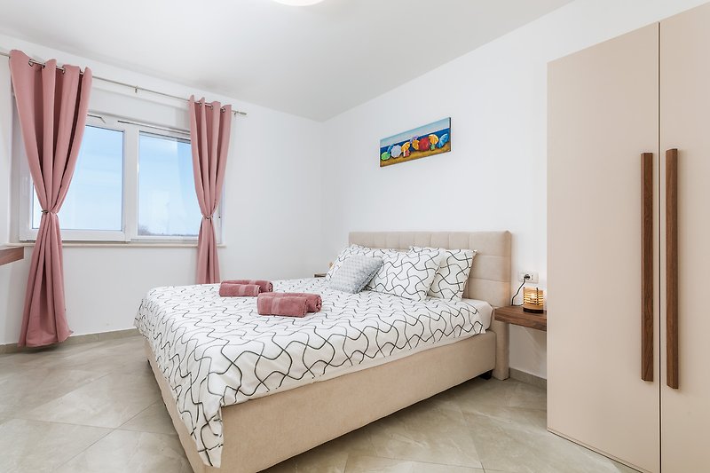 Stilvolles Schlafzimmer mit gemütlichem Bett und eleganten Vorhängen.