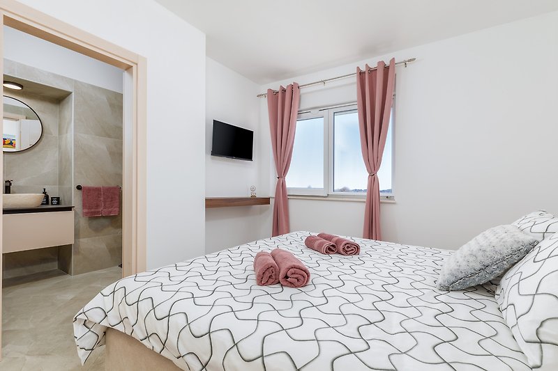 Stilvolles Schlafzimmer mit eleganten Vorhängen und gemütlichem Bett.