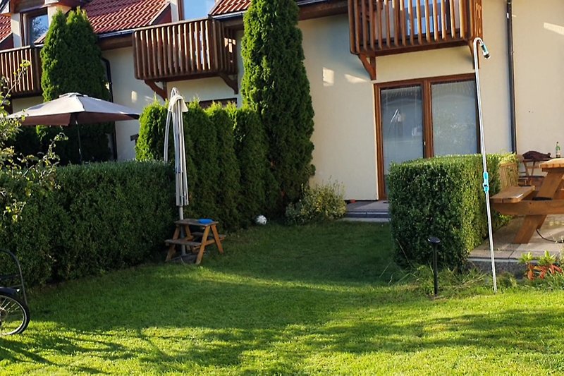 Ein idyllisches Ferienhaus mit Garten, Fahrrädern und grüner Landschaft.