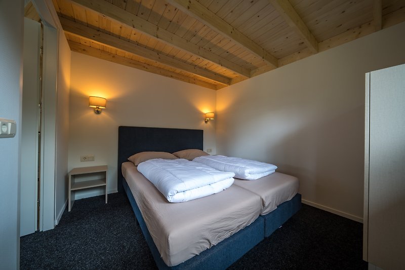 Elegantes Schlafzimmer mit stilvollem Holzbett und Lampen.