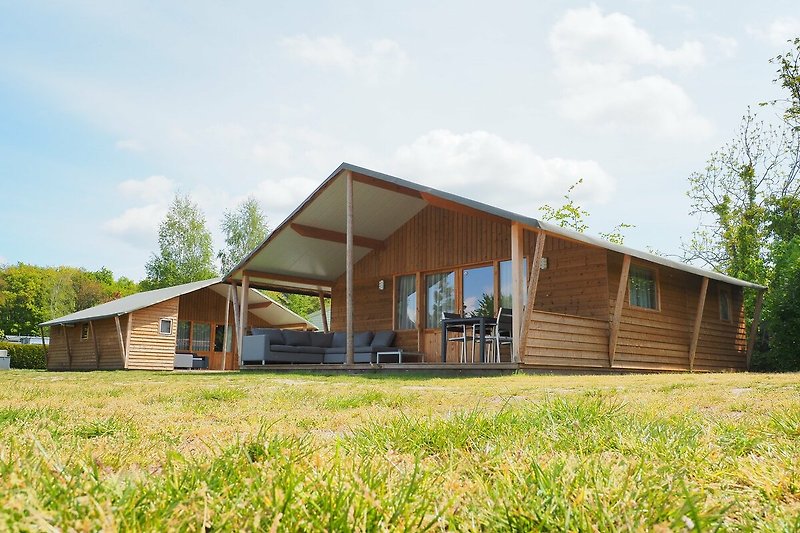 Ferienhaus mit Holzfassade und grüner Landschaft.